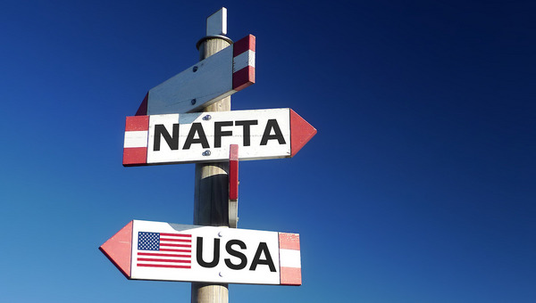 Zwei Schilder mit den Texten "NAFTA" und "USA", die in verschiedenen Richtungen zeigen