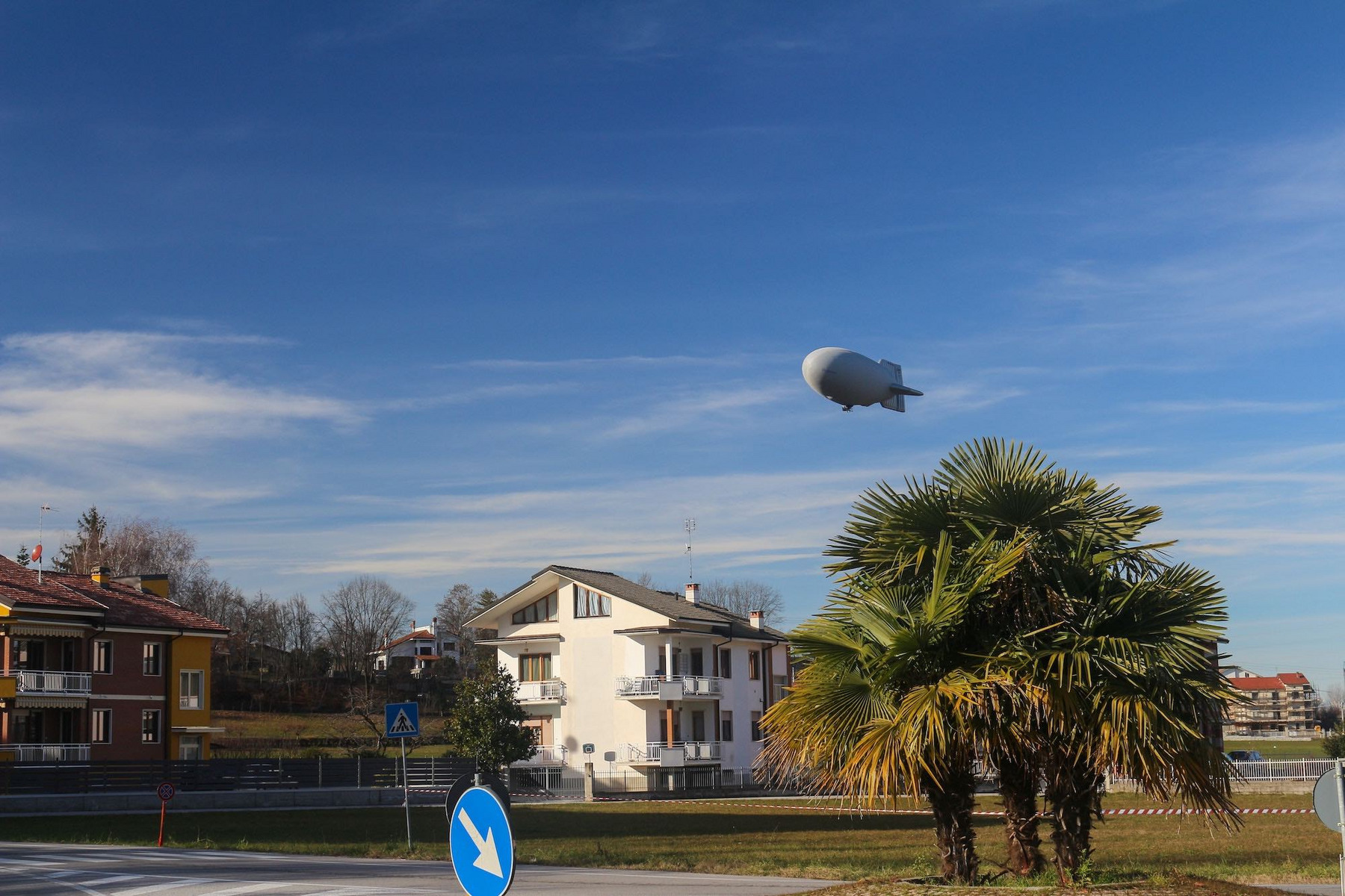 Ein vollstarres Luftschiff schwebt über Wohnhäusern
