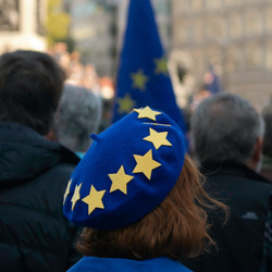 Eine Person auf einer Demo für Europa trägt eine blaue Mütze mit gelben Sternen