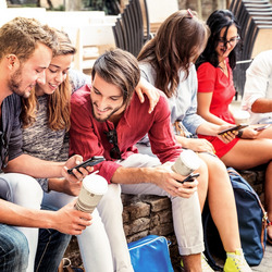 Jugendliche sitzen zusammen und schauen auf ihre Smartphones