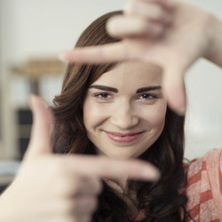 Eine Frau lächelt und macht mit ihren Fingern einen Rahmen