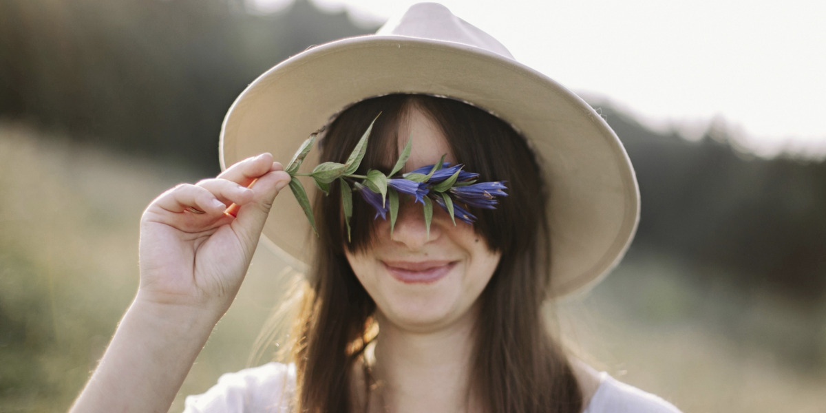 Person mit Enzian in der Hand