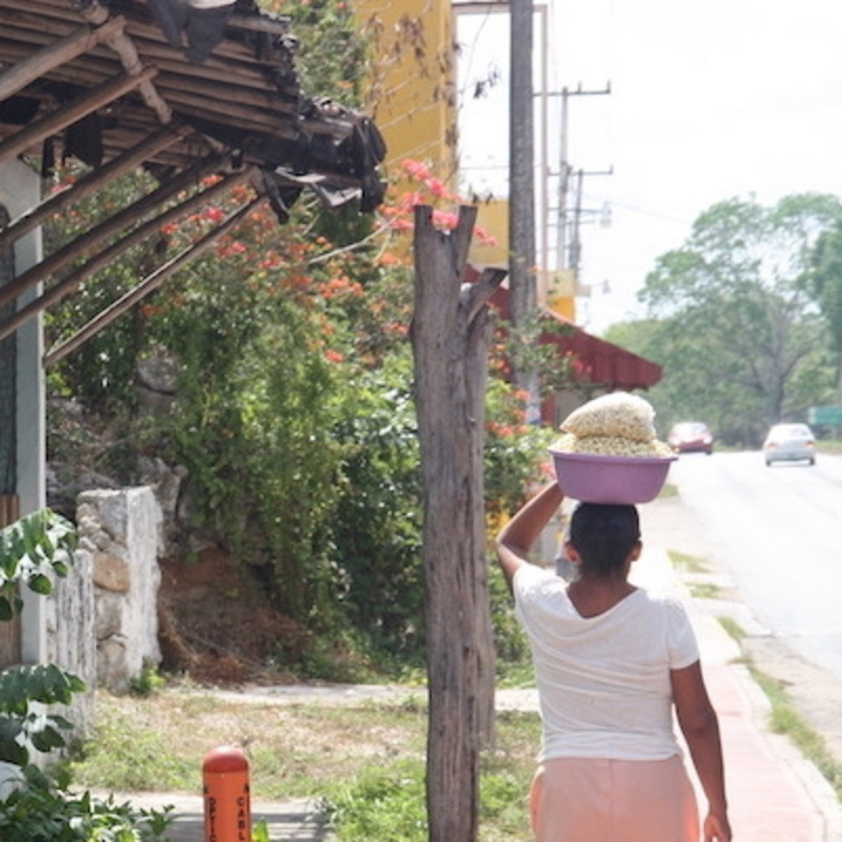 Eine Einheimische läuft durch Mexiko und balanciert Essen auf dem Kopf.