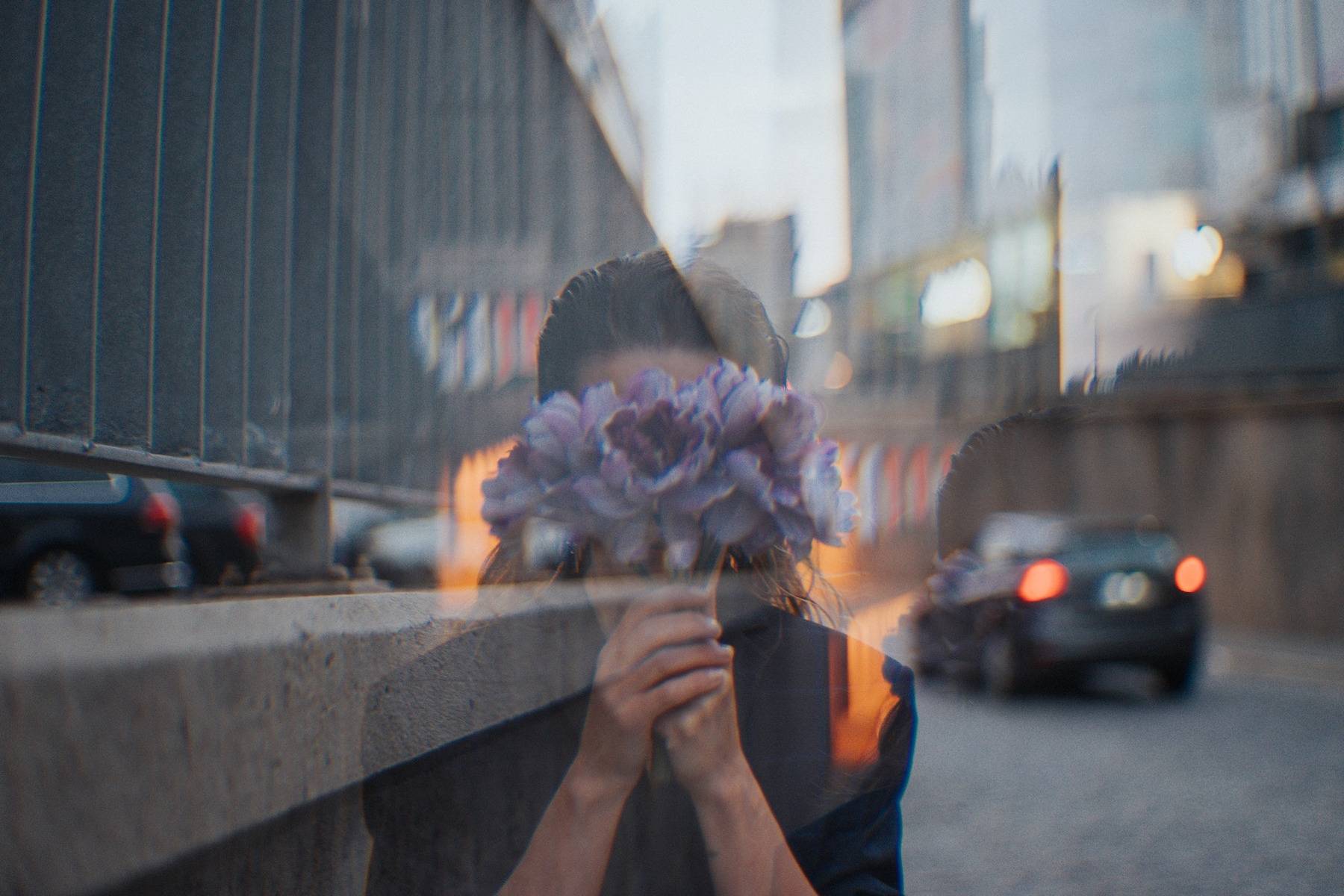 Eine Frau versteckt ihr Gesicht hinter einem Strauß Blumen