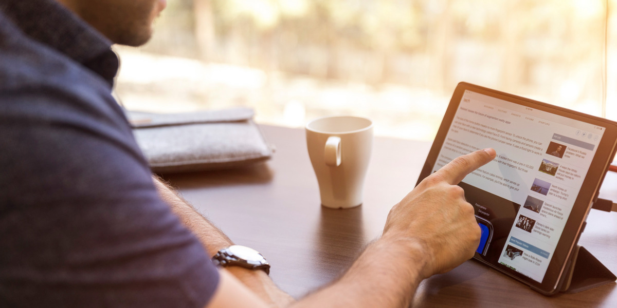 Ein Mann bedient ein Tablet, das auf einem Tisch steht