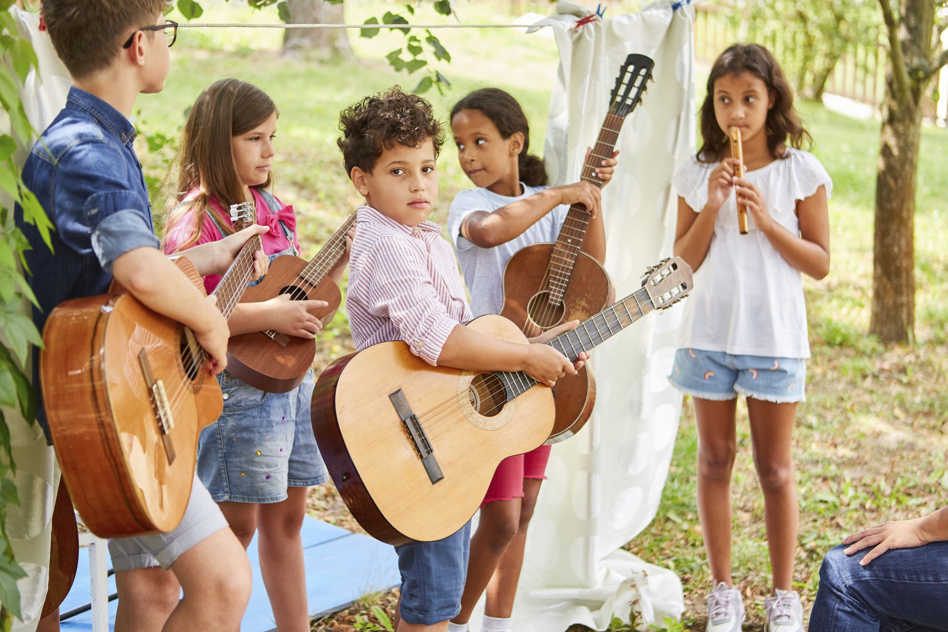 Kinder spielen draussen Gitarre