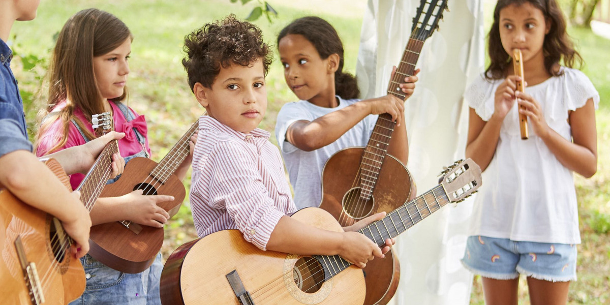 Kinder spielen draussen Gitarre