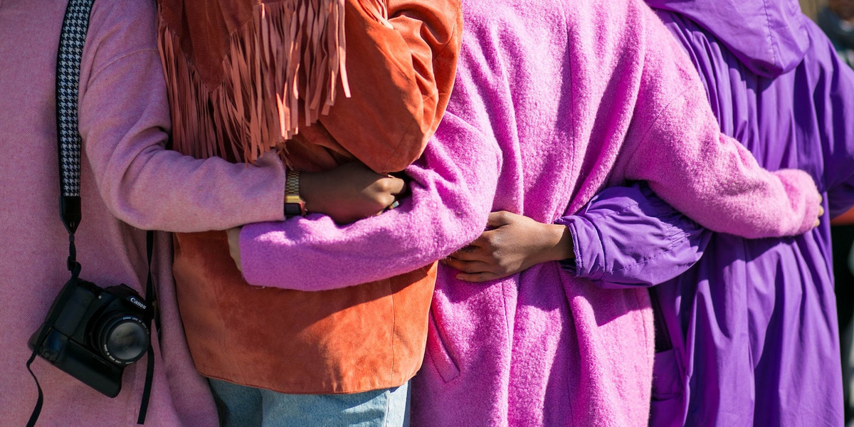 Personen in verschiedenfarbigen Mänteln von hinten aufgenommen