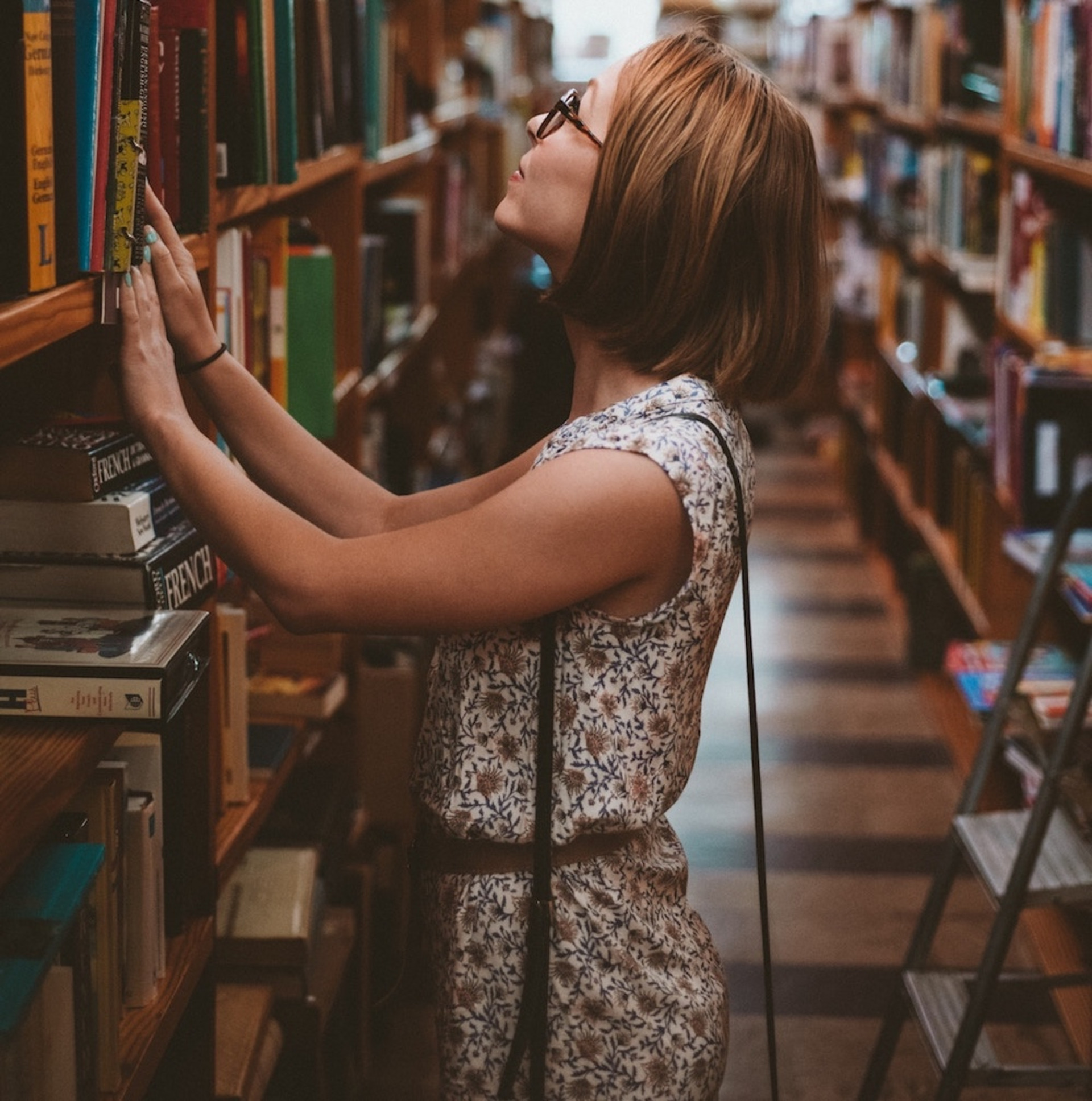 Eine Person steht vor einem Bücherregal.