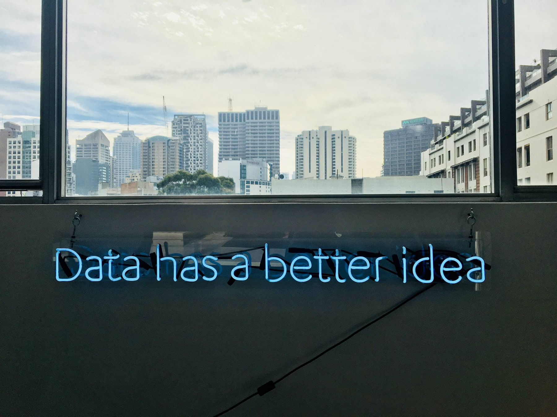 Ein blaues Neonschild im Büro: "Data has a better idea."