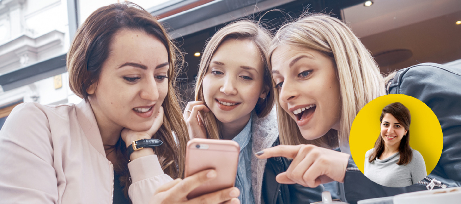 Drei Frauen schauen auf ein Smartphone.