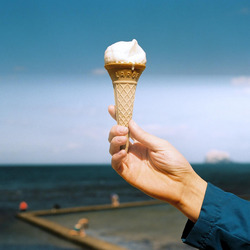 Eine Hand hält eine Eiswaffel Strand.