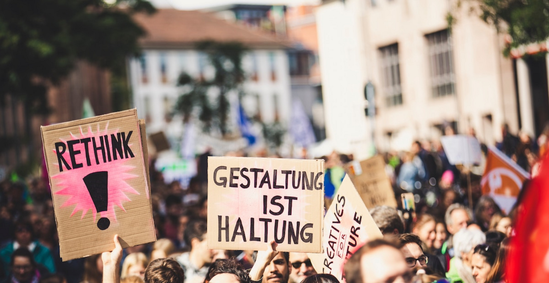 Menschen bei einer Demo halten Schilder mit den Texten "Rethink" und "Gestaltung ist Haltung"