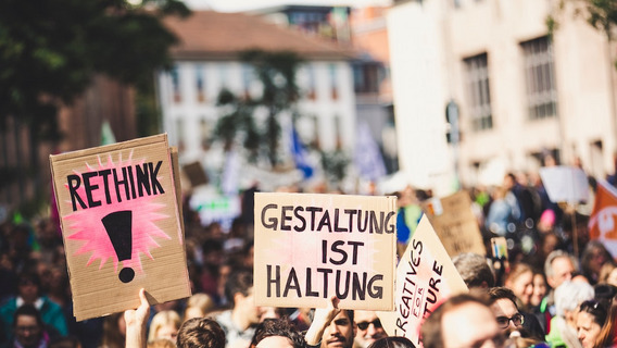 Menschen bei einer Demo halten Schilder mit den Texten "Rethink" und "Gestaltung ist Haltung"