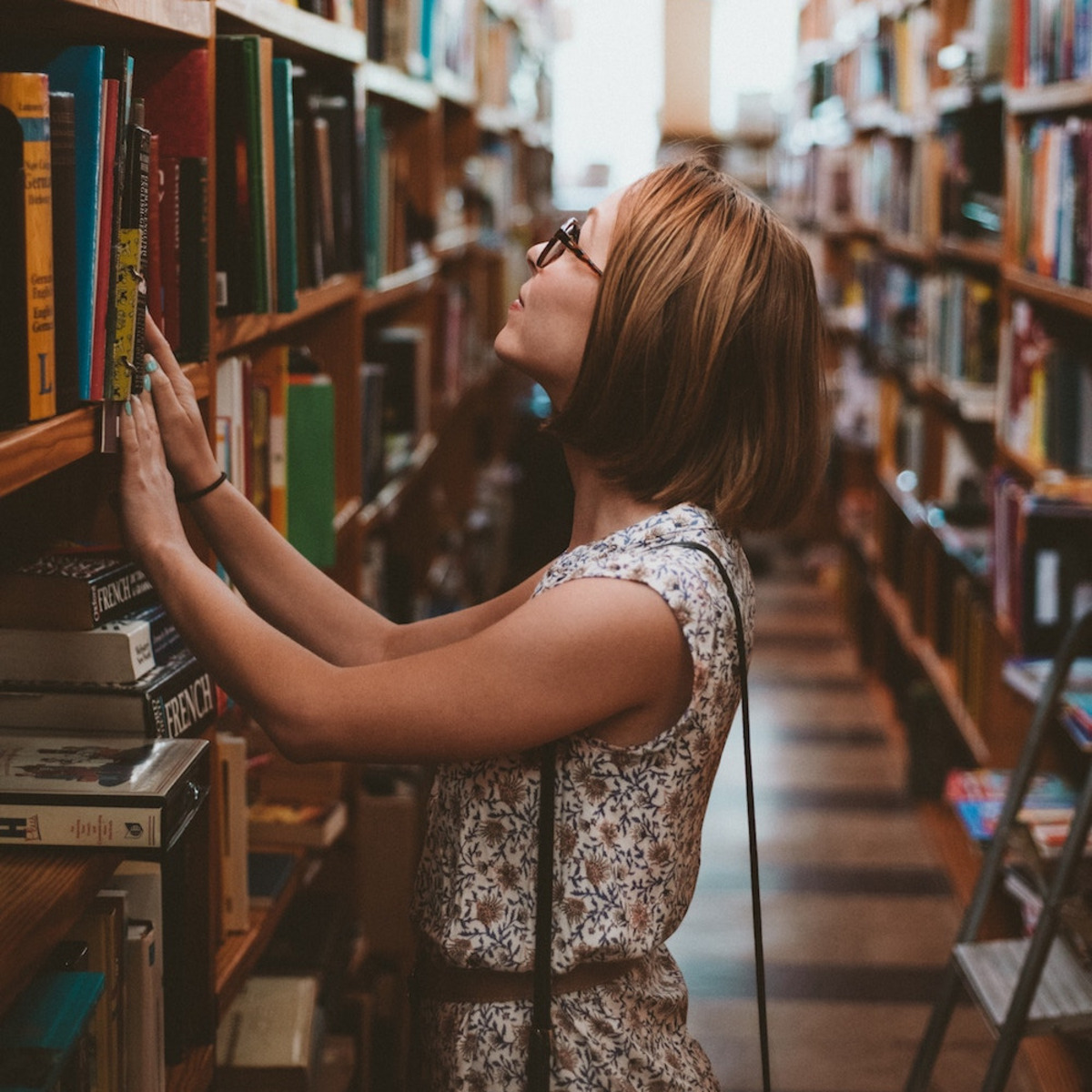 Eine Person steht vor einem Bücherregal.