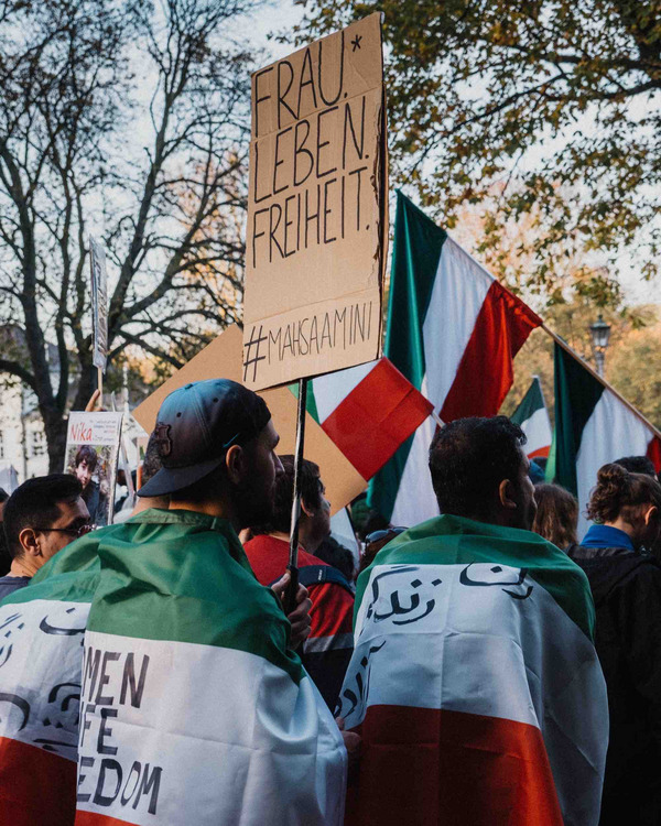 Ein Demonstrant hält ein Schild mit der Aufschrift "Frau. Leben. Freiheit. #Mahsaamini"