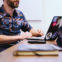 Ein Mann sitzt an einem Laptop