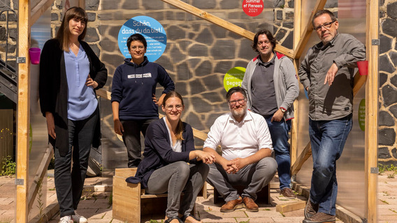 Das Foto zeigt sechs Personen, die für ein Gruppenfoto posieren. Es handelt sich um Teilnehmer:innen des "Summer of Pioneers", ganz links außen steht Sarah Ackermann.