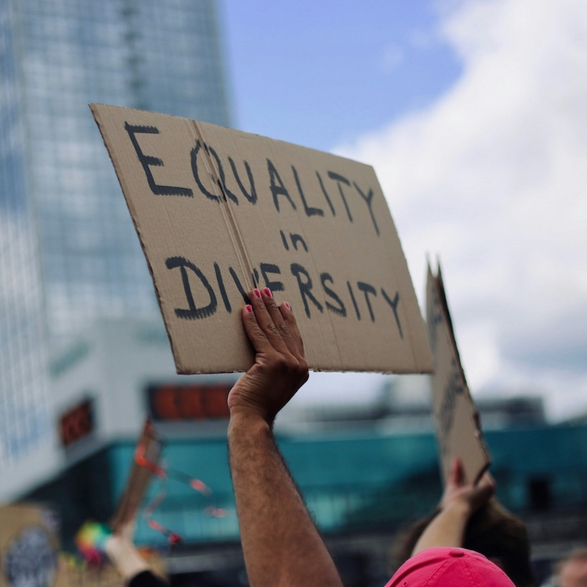 Auf einer Demonstration hält eine Hand ein Pappschild mit der Aufschrift „Equality in Diversity“ hoch