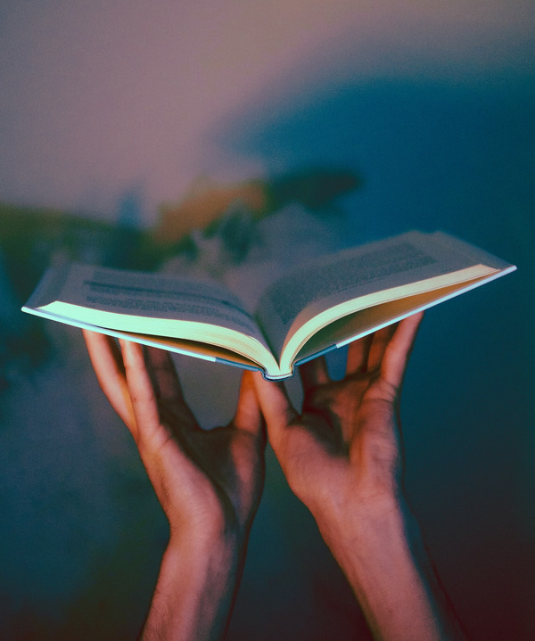 Zwei Hände halten ein Buch auf