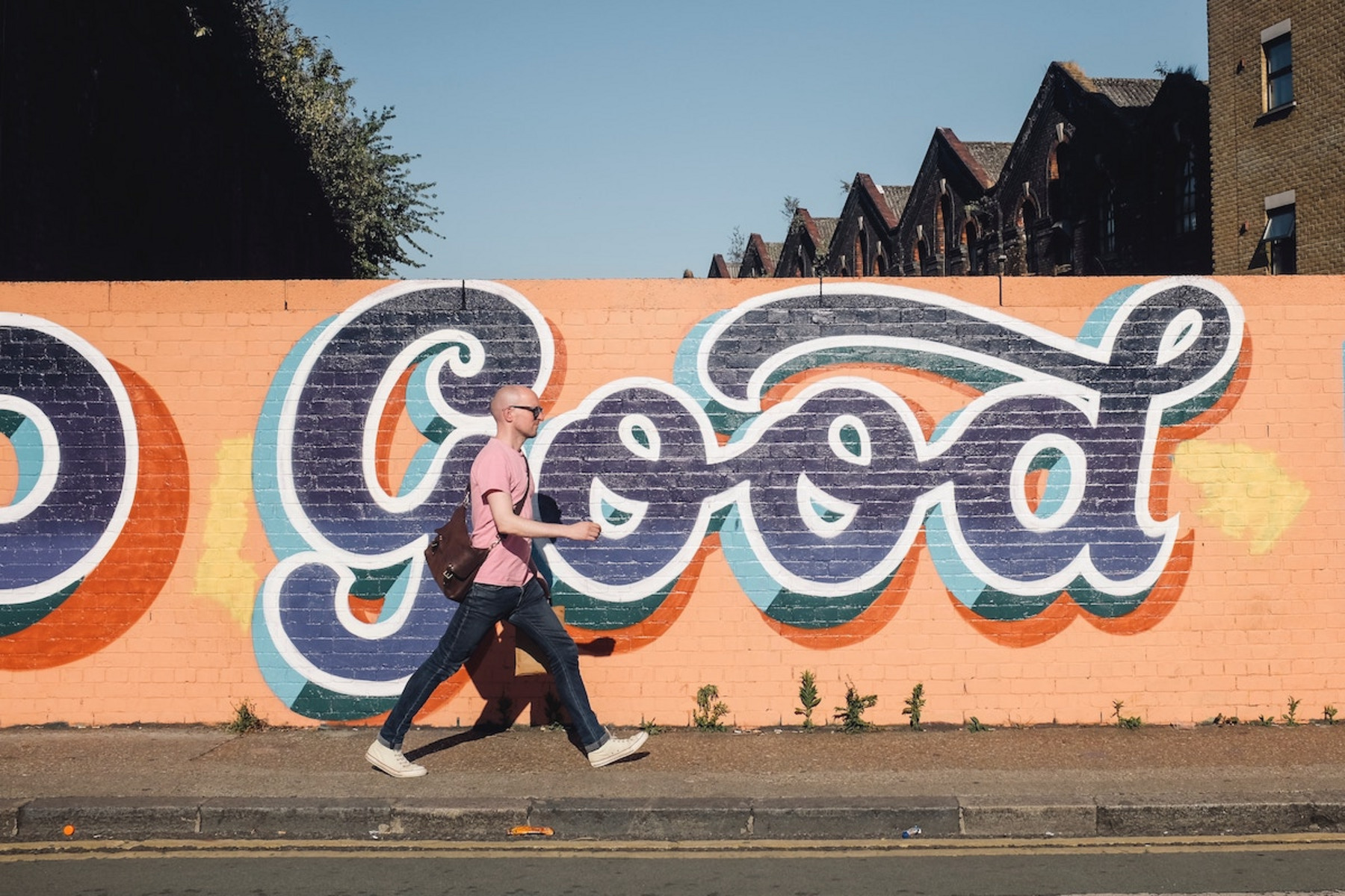 Eine Person läuft an einem Wandgemälde vorbei, auf dem "Good" steht