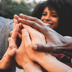 Menschen stehen im Kreis zusammen und geben High-Fives