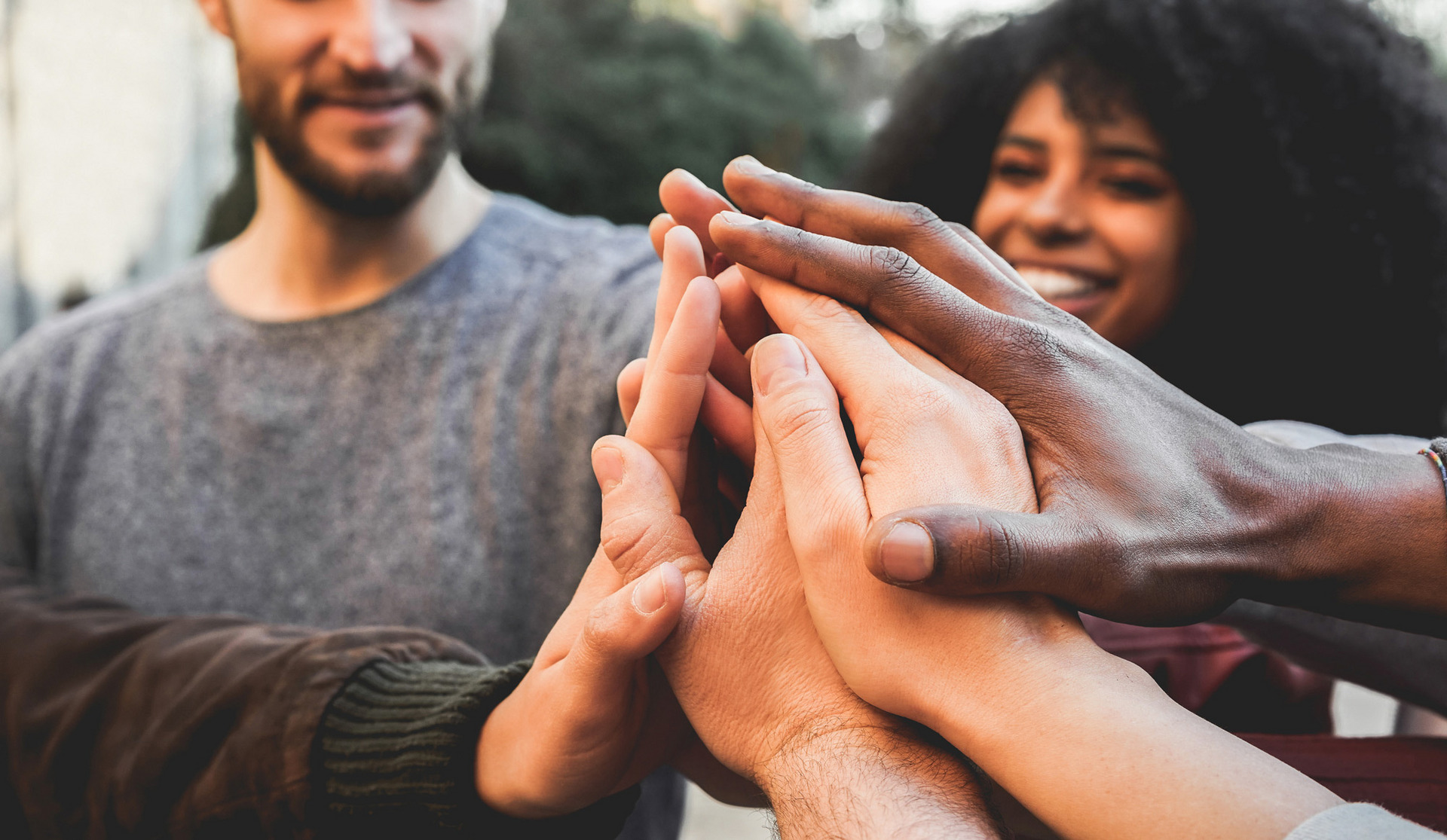 Menschen stehen im Kreis zusammen und geben High-Fives