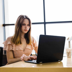 Eine junge Frau arbeitet an einem Notebook.