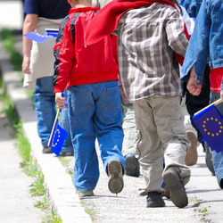 Menschen mit EU-Flaggen gehen auf dem Bürgersteig