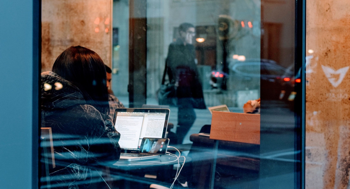 Eine Person sitzt in einem Café am Laptop