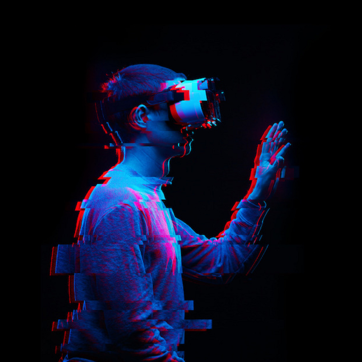 Eine Person trägt eine Virtual-Reality-Brille und greift mit der Hand in der Luft.