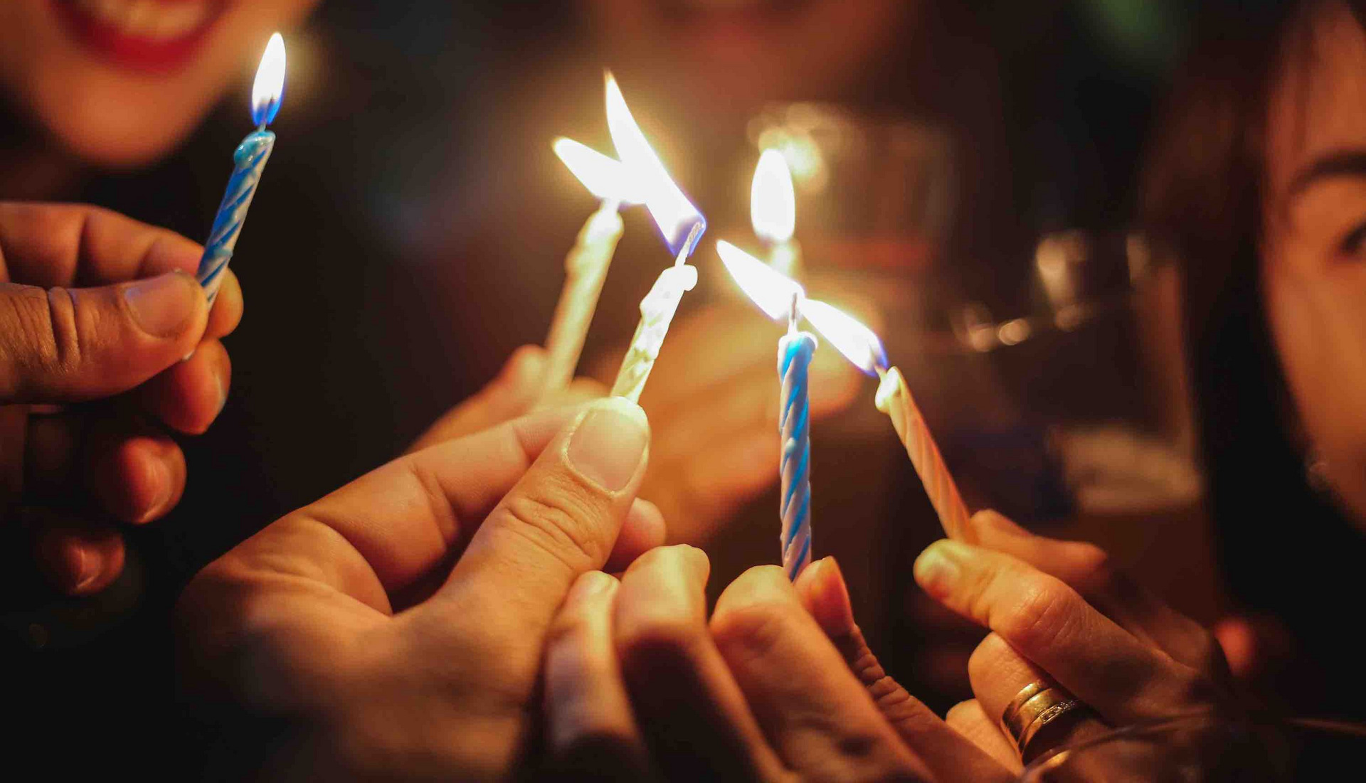 Eine Gruppe Menschen zündet Kerzen an