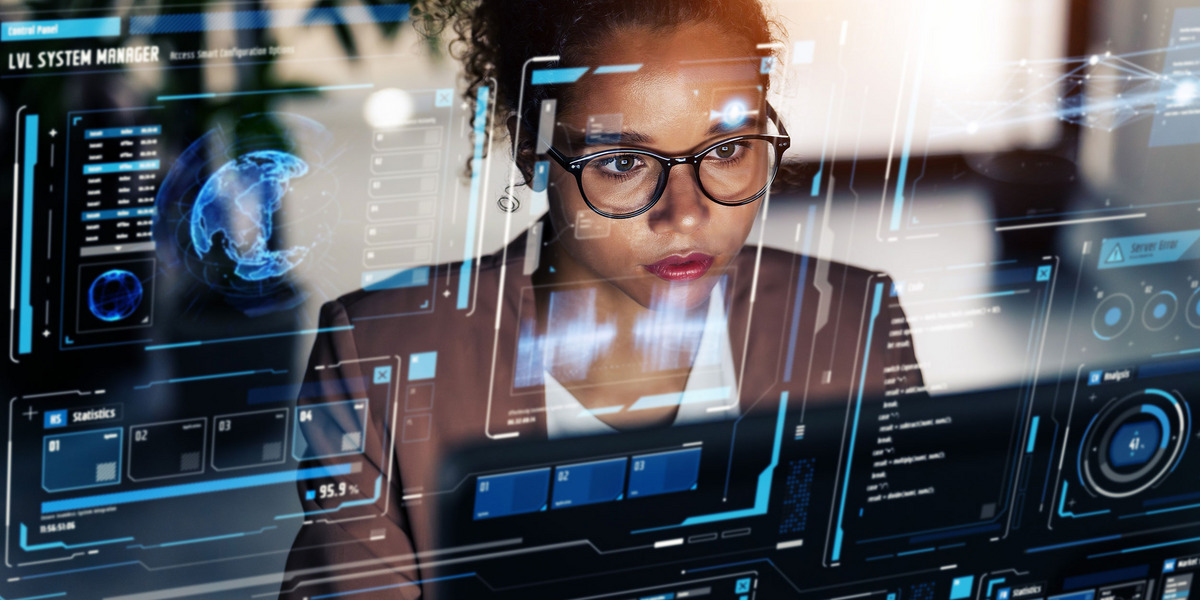Eine Frau mit Brille schaut konzentriert auf einen großen, transparenten Bildschirm mit futuristischer Benutzeroberfläche.