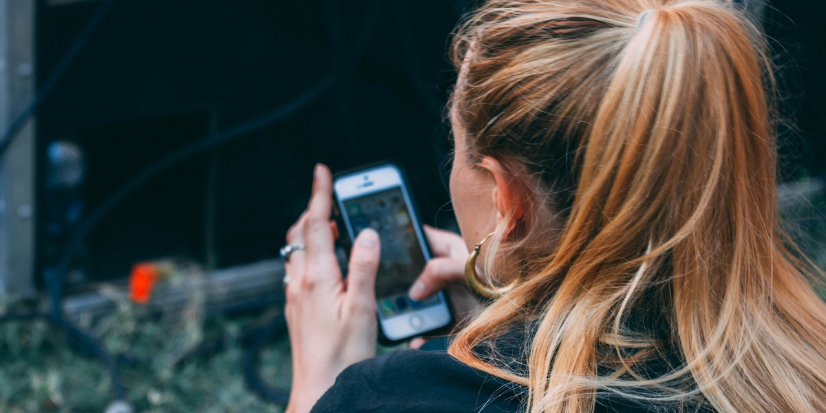 Eine Frau tippt auf ihrem Handy.