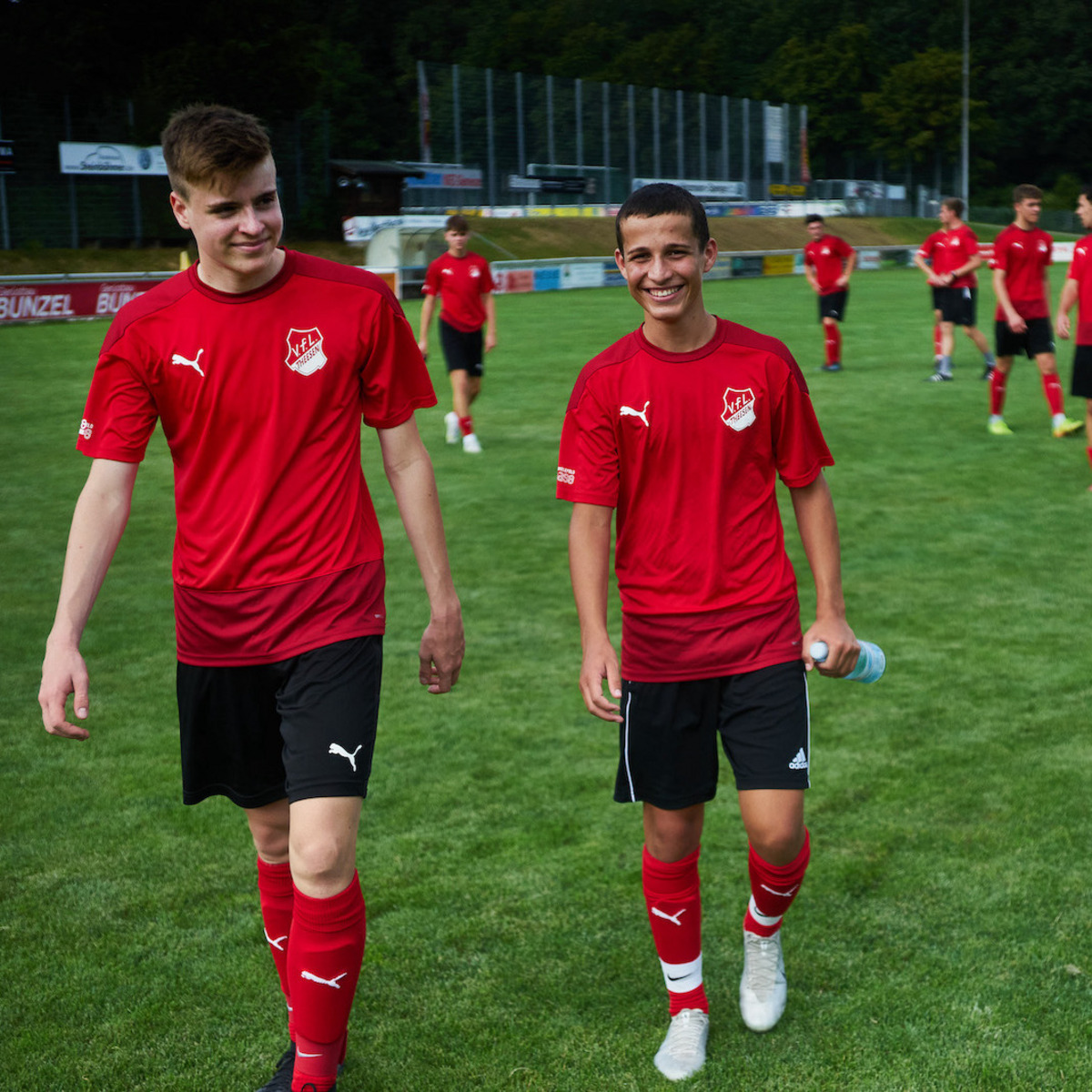 Fußballmannschaft auf dem Spielfeld in roten Trikots