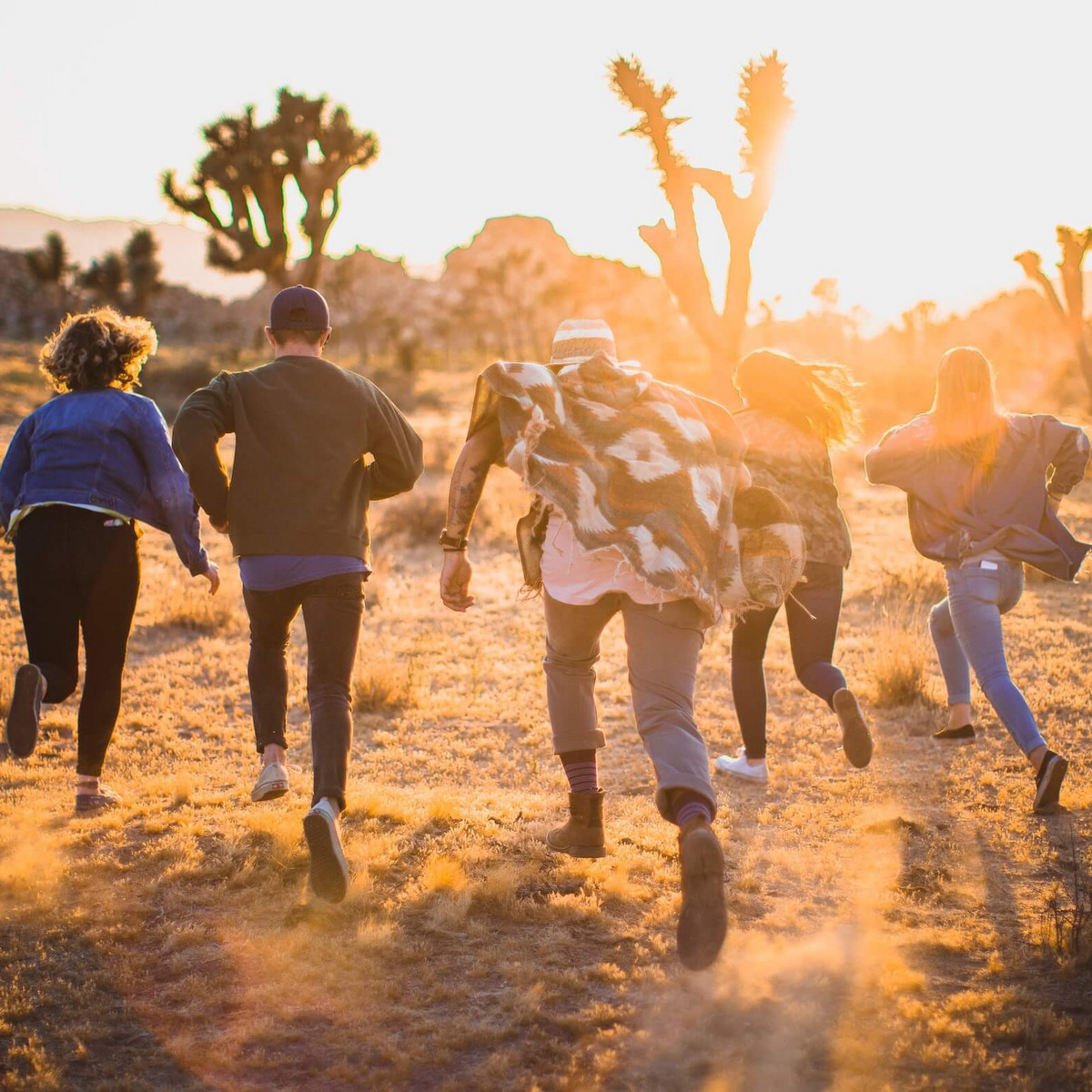 Eine Gruppe junger Menschen rennt durch die Wüste