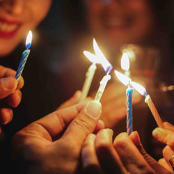 Eine Gruppe Menschen zündet Kerzen an