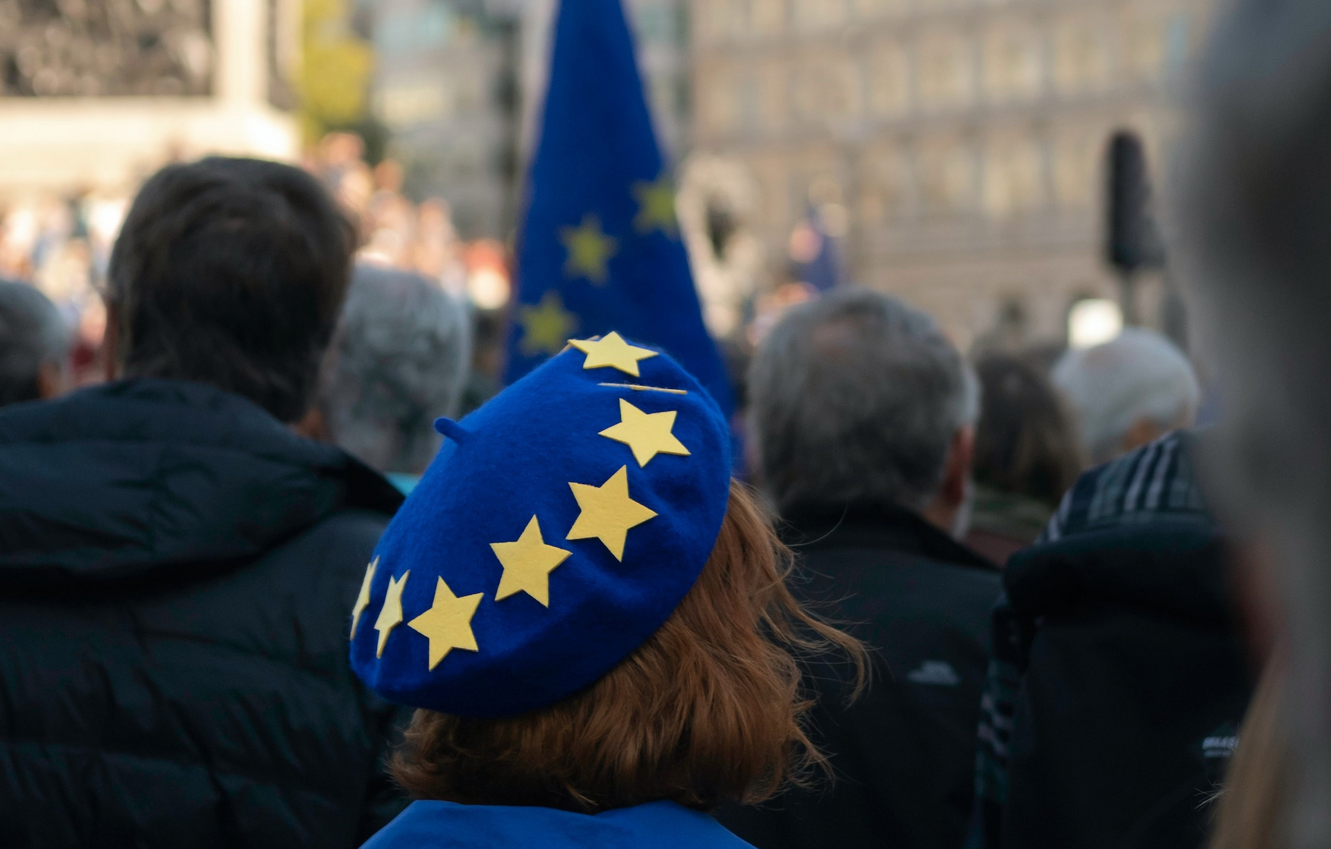 Eine Person auf einer Demo für Europa trägt eine blaue Mütze mit gelben Sternen