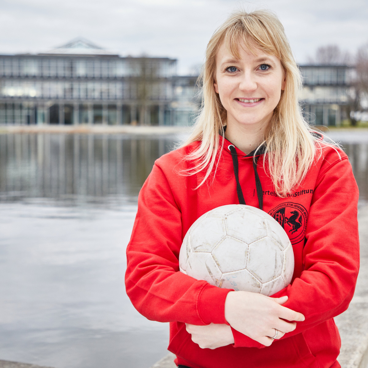 Julia Tegeler mit einem Ball in der Hand vor der Bertelsmann Stiftung