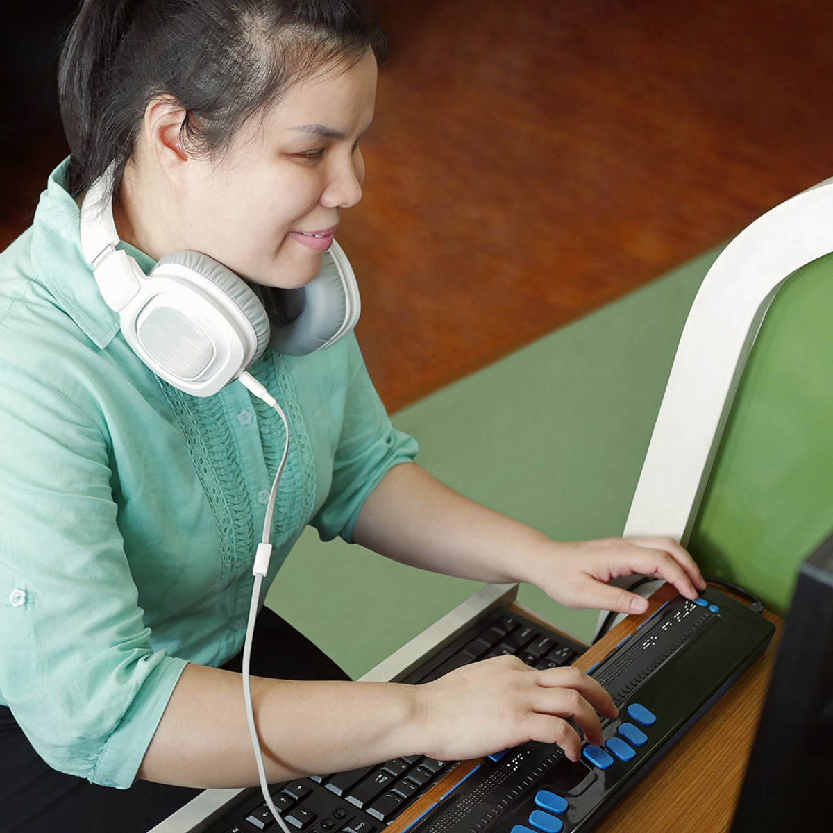 Eine blinde Frau bedient einen Computer mithilfe eines Screenreaders.
