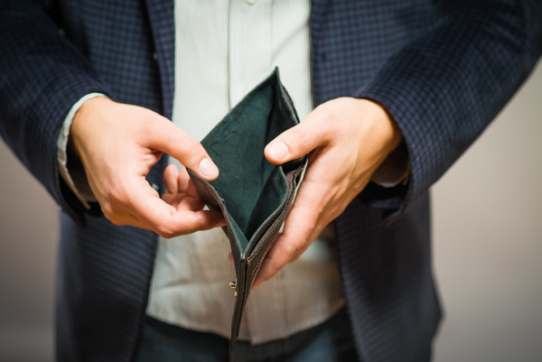 Ein Mann zeigt einen leeren Geldbeutel.