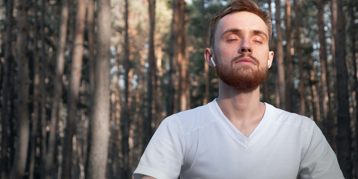 Eine Person sitzt im Wald und meditiert