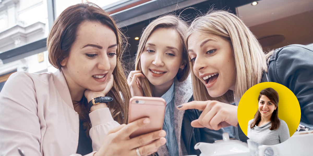 Drei Frauen schauen auf ein Smartphone.