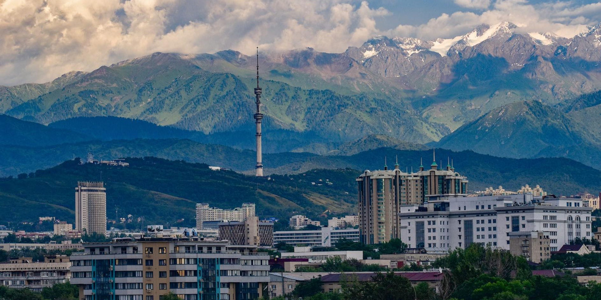 Stadt in Kasachstan mit Fernsehturm vor Berglandschaft