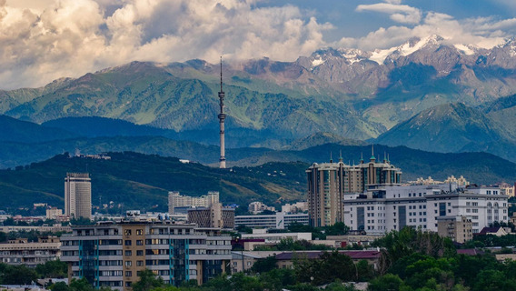 Stadt in Kasachstan mit Fernsehturm vor Berglandschaft