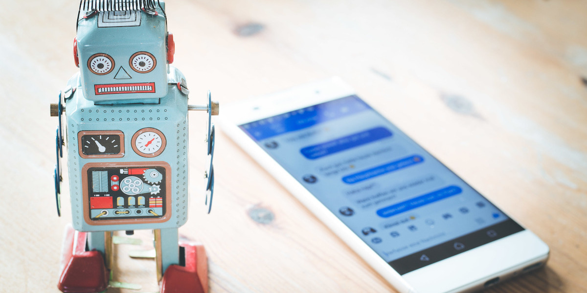 Ein Spielzeugroboter steht neben einem Smartphone