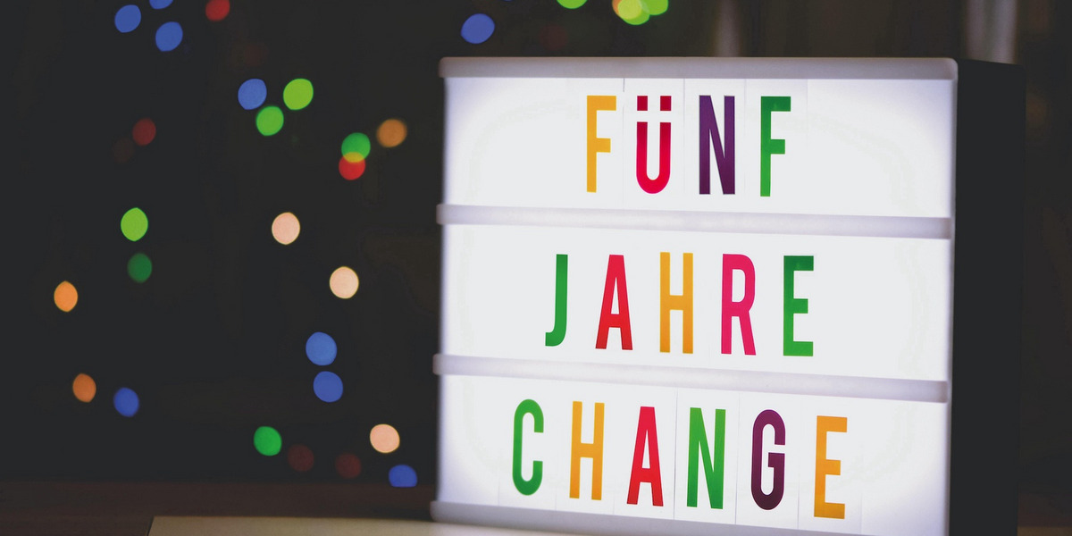 Ein Foto eines Leuchtkastens, in dem mit bunten Buchstaben steht "FÜNF JAHRE CHANGE".