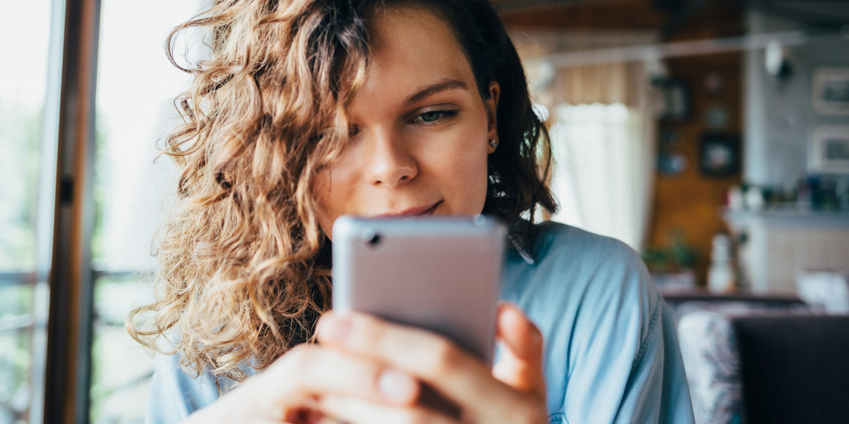 Eine Frau scrollt durch Social-Media-Feeds.
