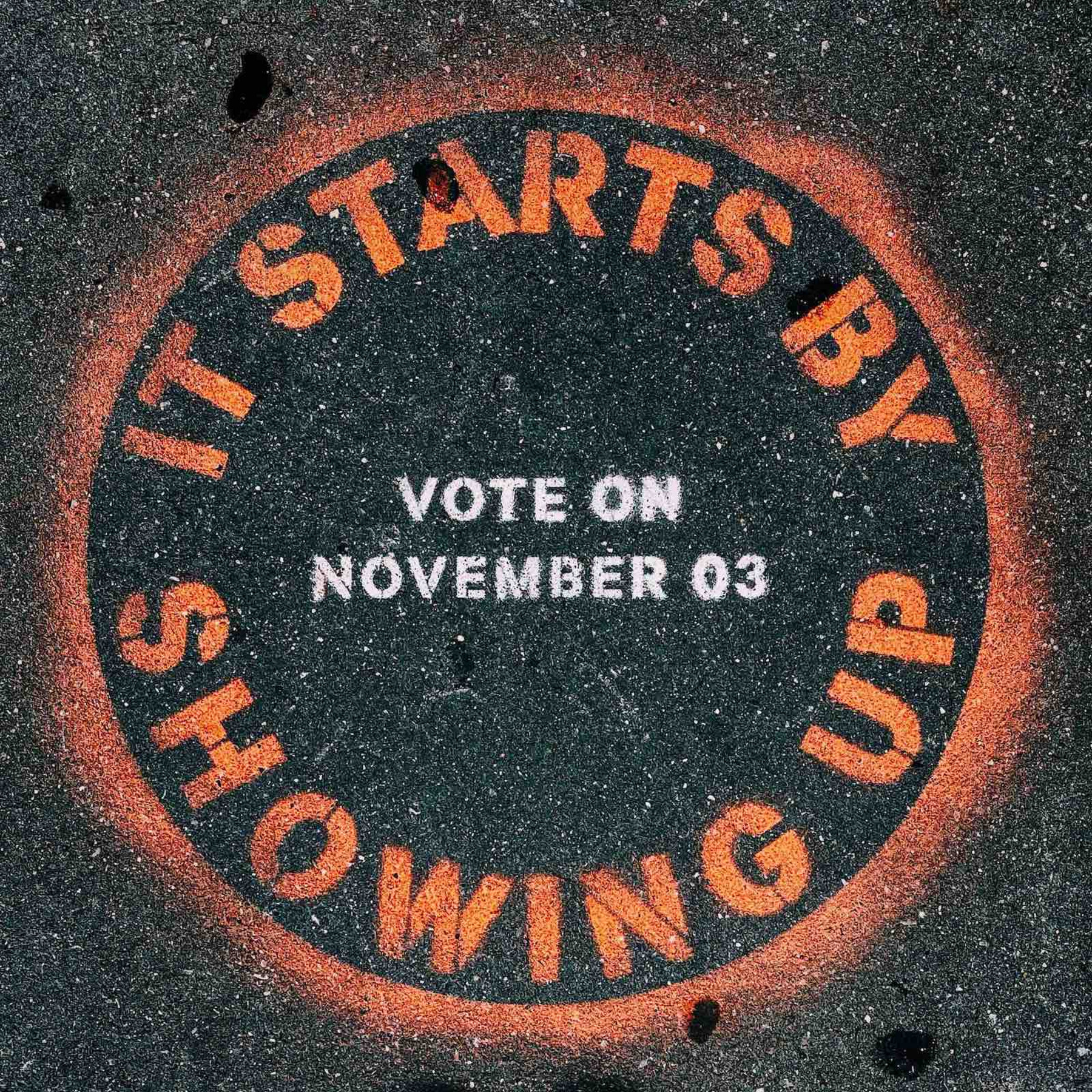 Eine gesprayte Botschaft auf dem Boden: „It starts by showing up. Vote on November 03“