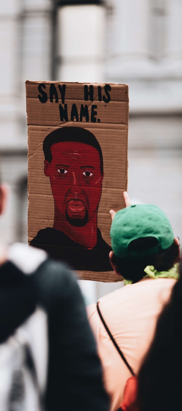 Protest mit Schild, das George Floyd abbildet